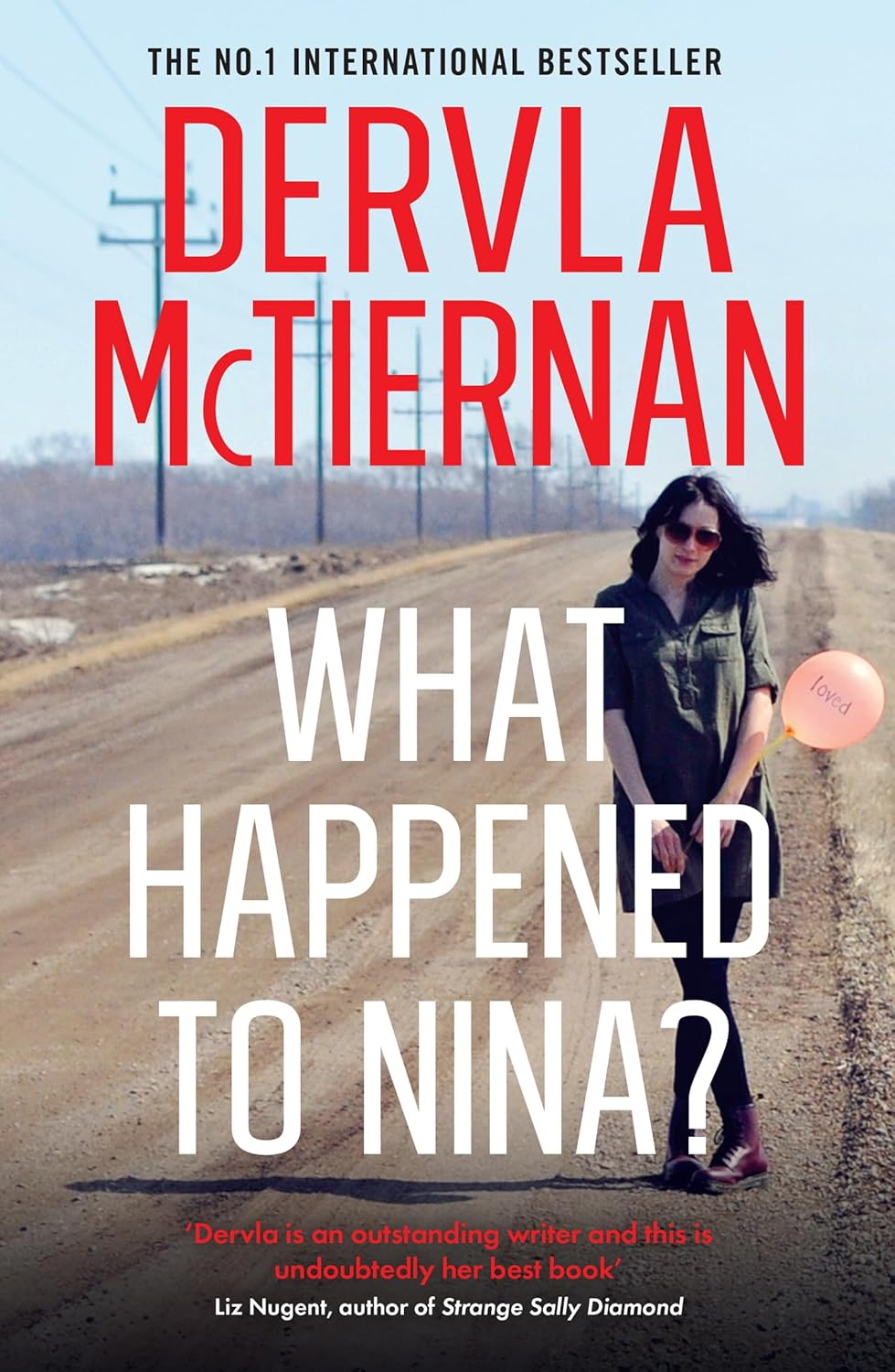 'What Happened To Nina?' by Dervla McTiernan book cover. The background is a desert/mountain scene and there is a girl in all black walking.